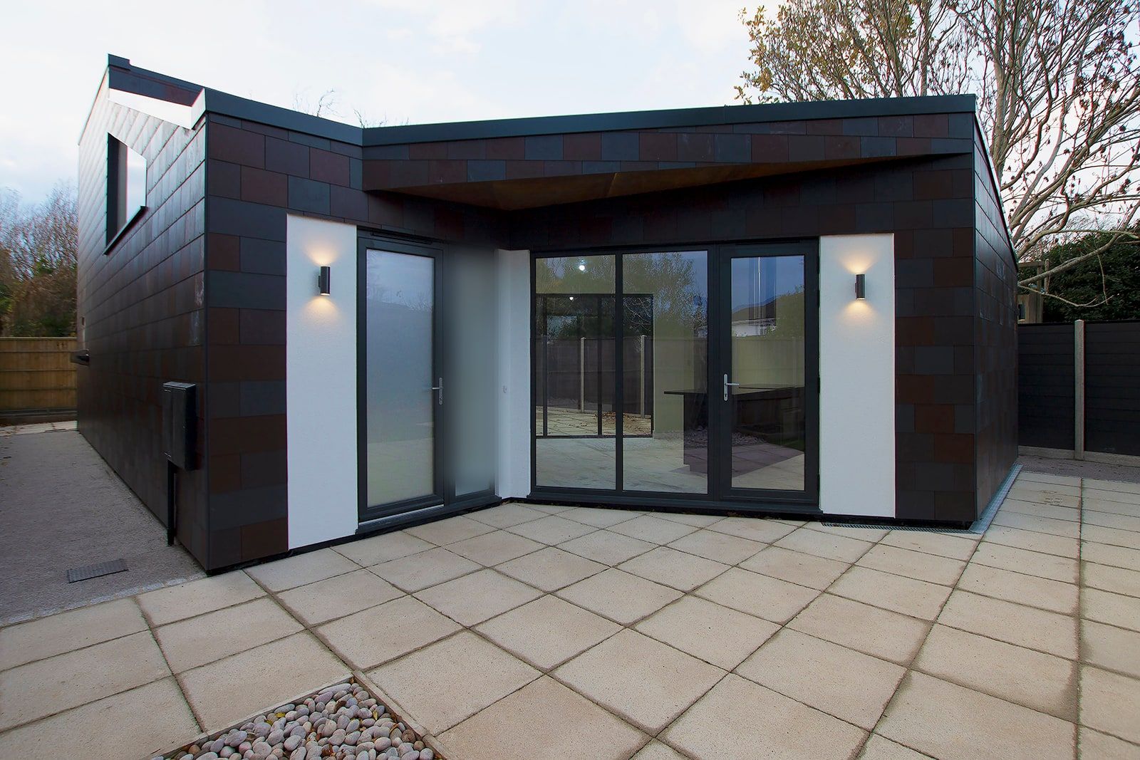Paved terrace in the sheltered corner where the two wings meet, glazed on both sides, new build retirement house, Fareham.
