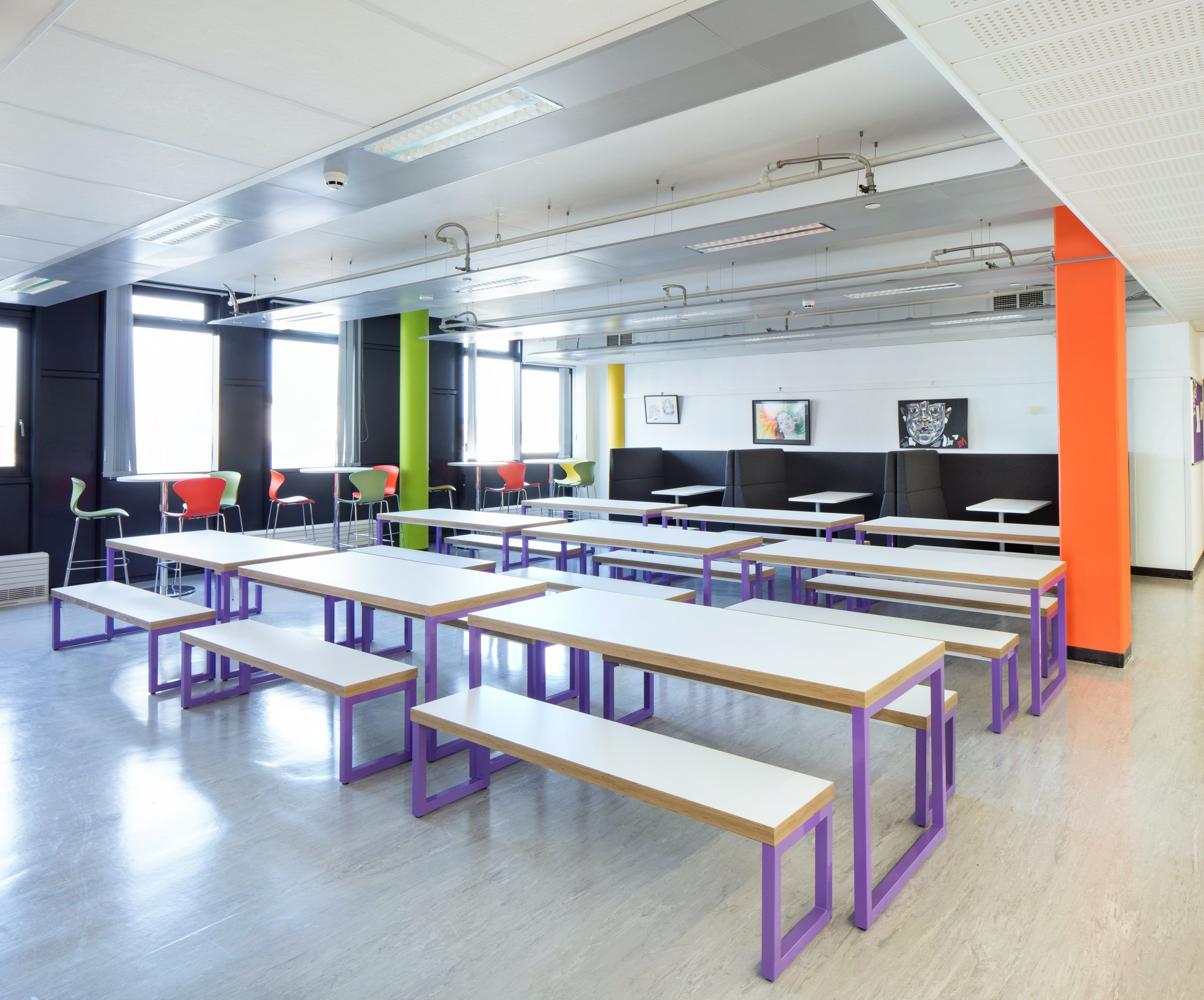 White benches and dark booths under the windows of the remodelled eating space, 6th Form Centre, Newbury.