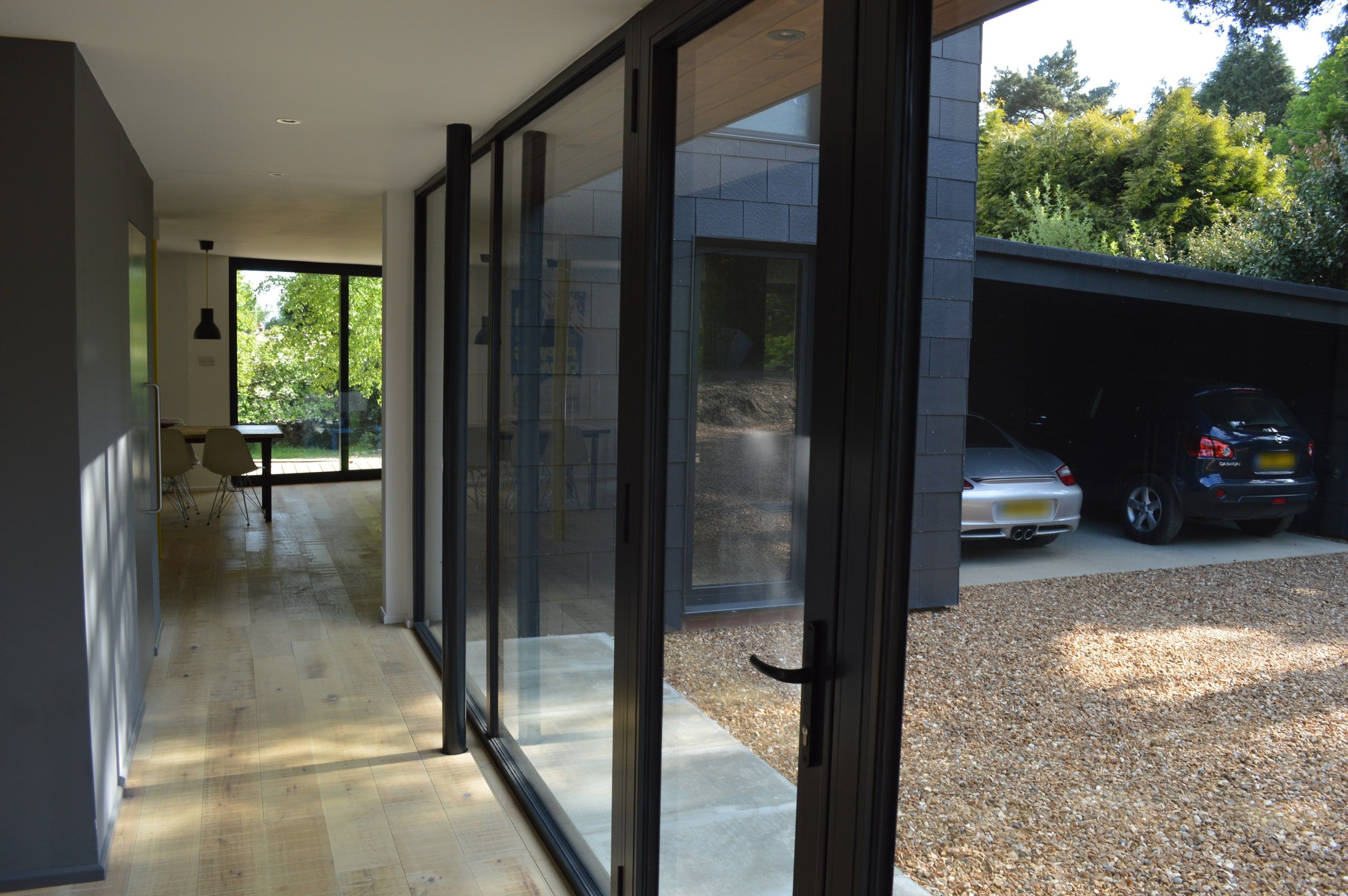 Full-height glazing along the oak-floored entrance hall, looking out to the carport, 1960s house, Haslemere.