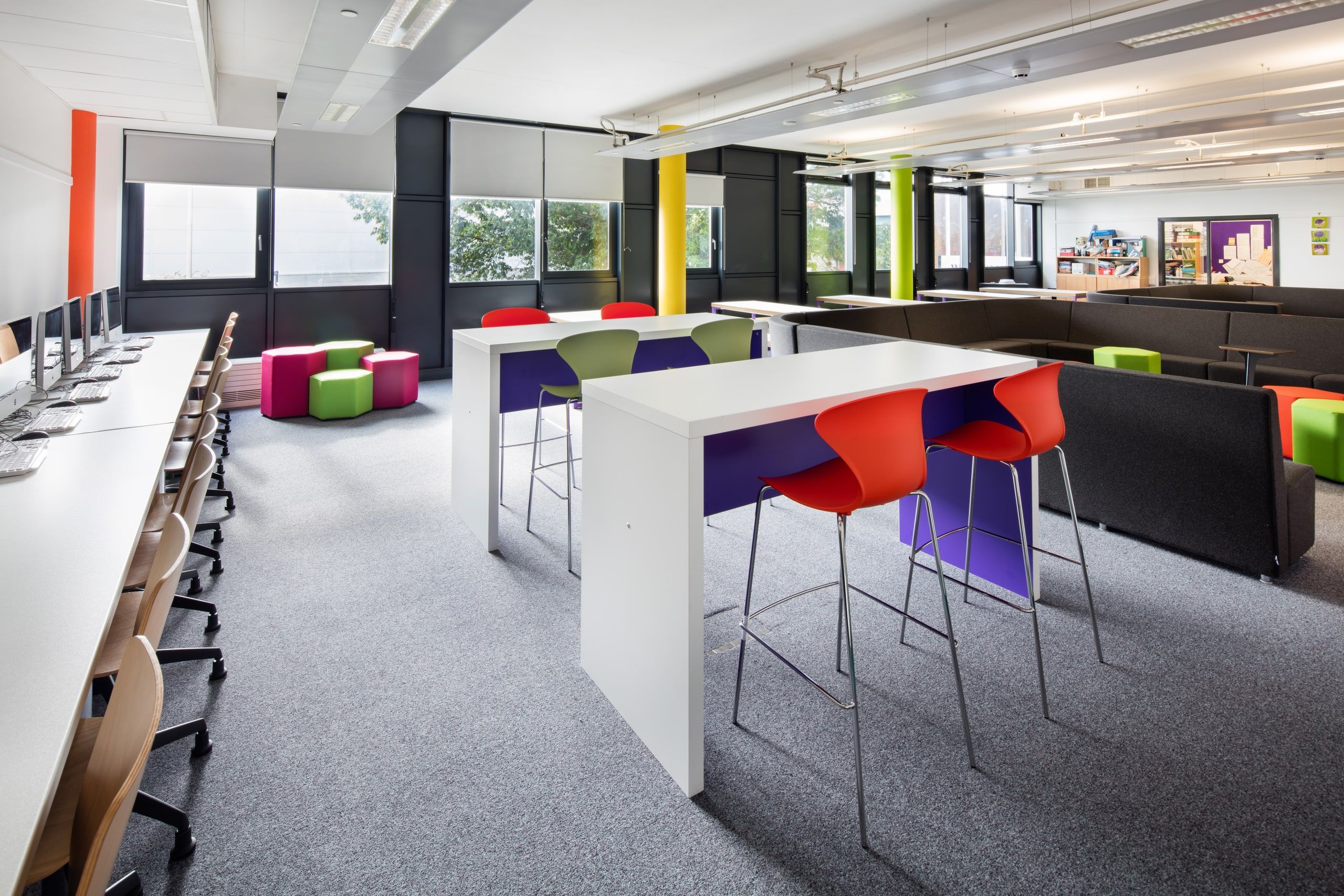 High collaborative tables with red and green stools in the new learning zone, 6th Form Centre, Newbury.