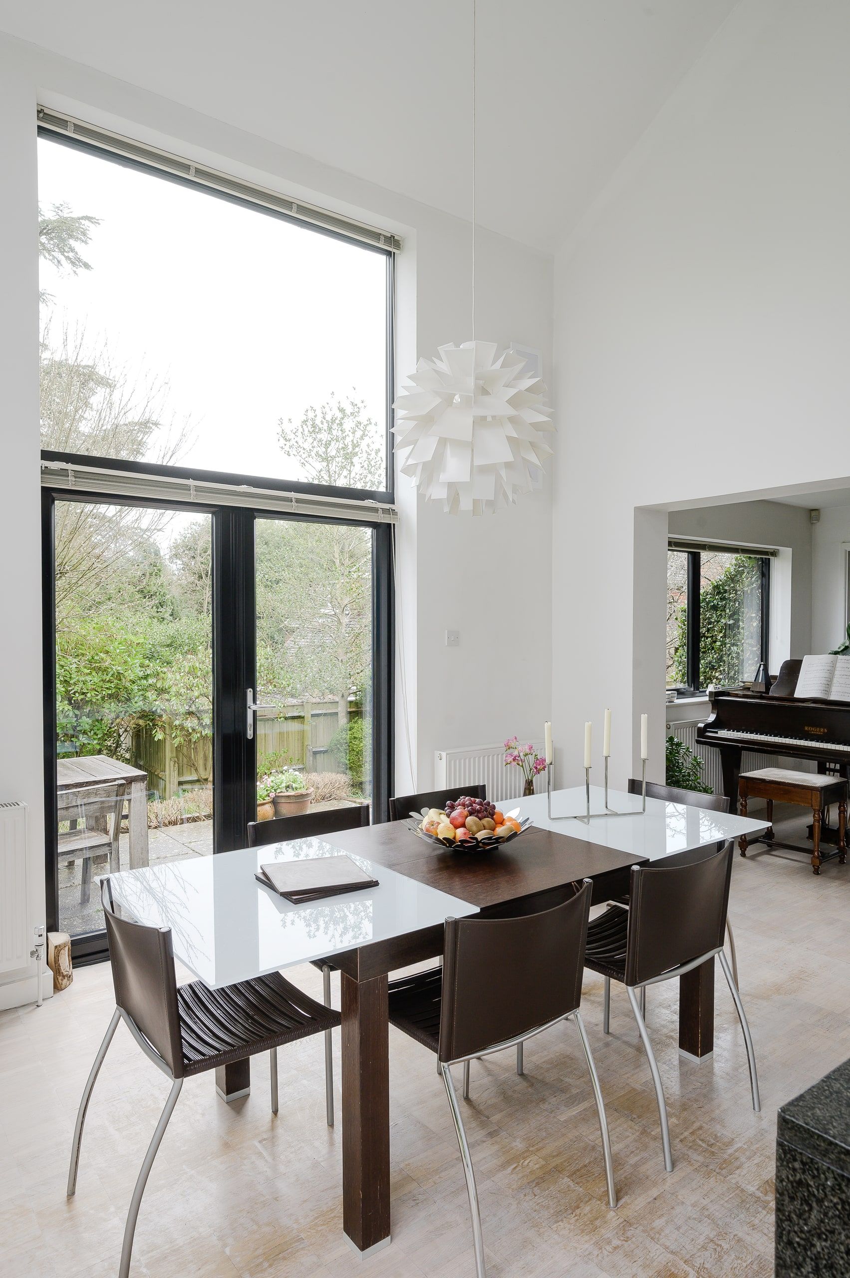 Double-height glazing and a pendant light above the dining table, 1960s house, Fernhurst.