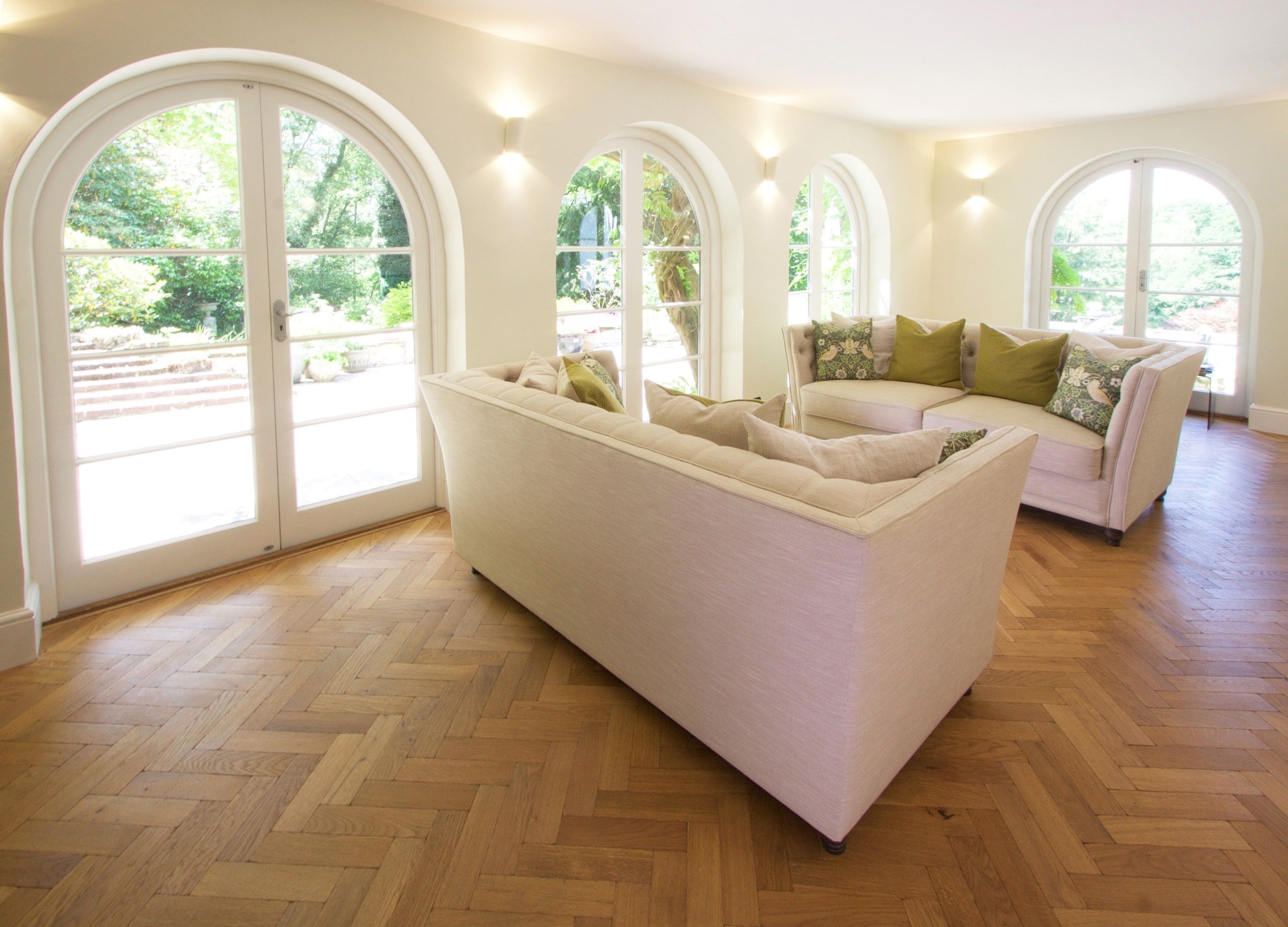 Sitting room with herringbone parquet and arched doors to the garden, 1930s country house, Mole Valley.