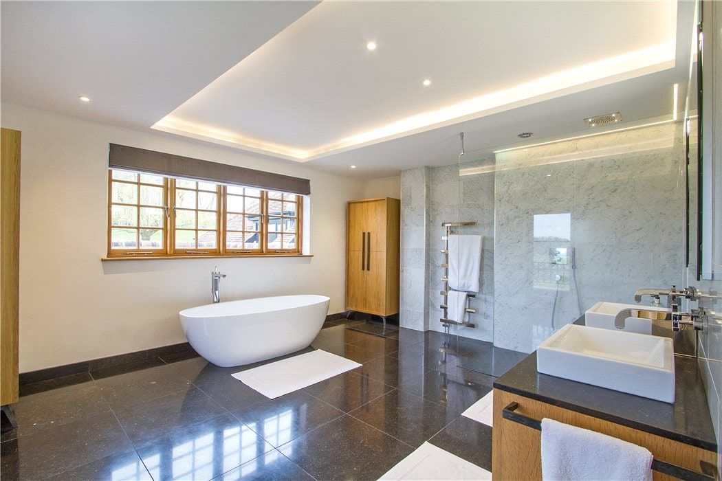 Freestanding bath below a leaded mullioned window in the master bathroom, listed country house, Chiddingfold.
