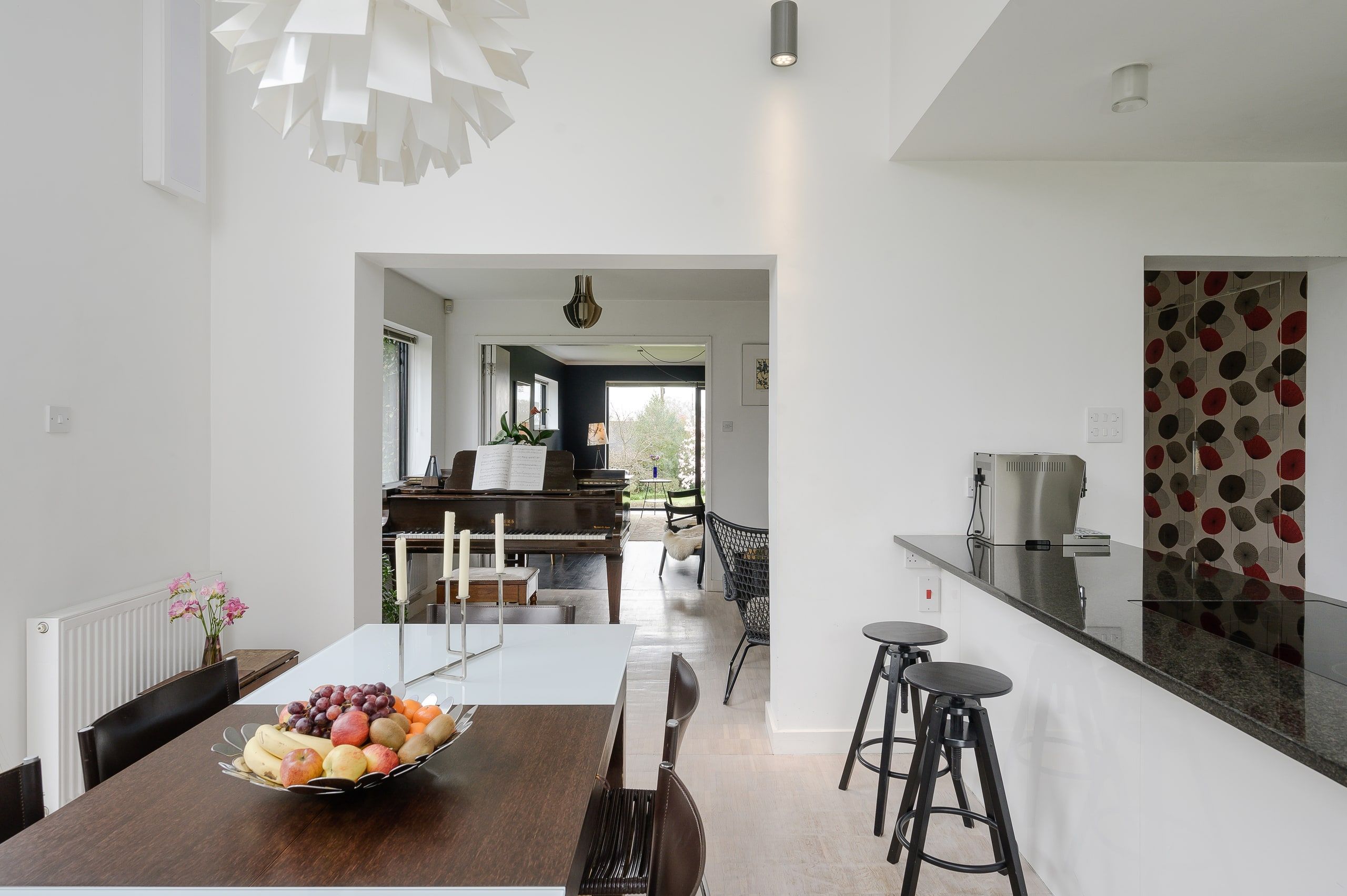 Breakfast bar stools and a long view through the open-plan ground floor, 1960s house, Fernhurst.