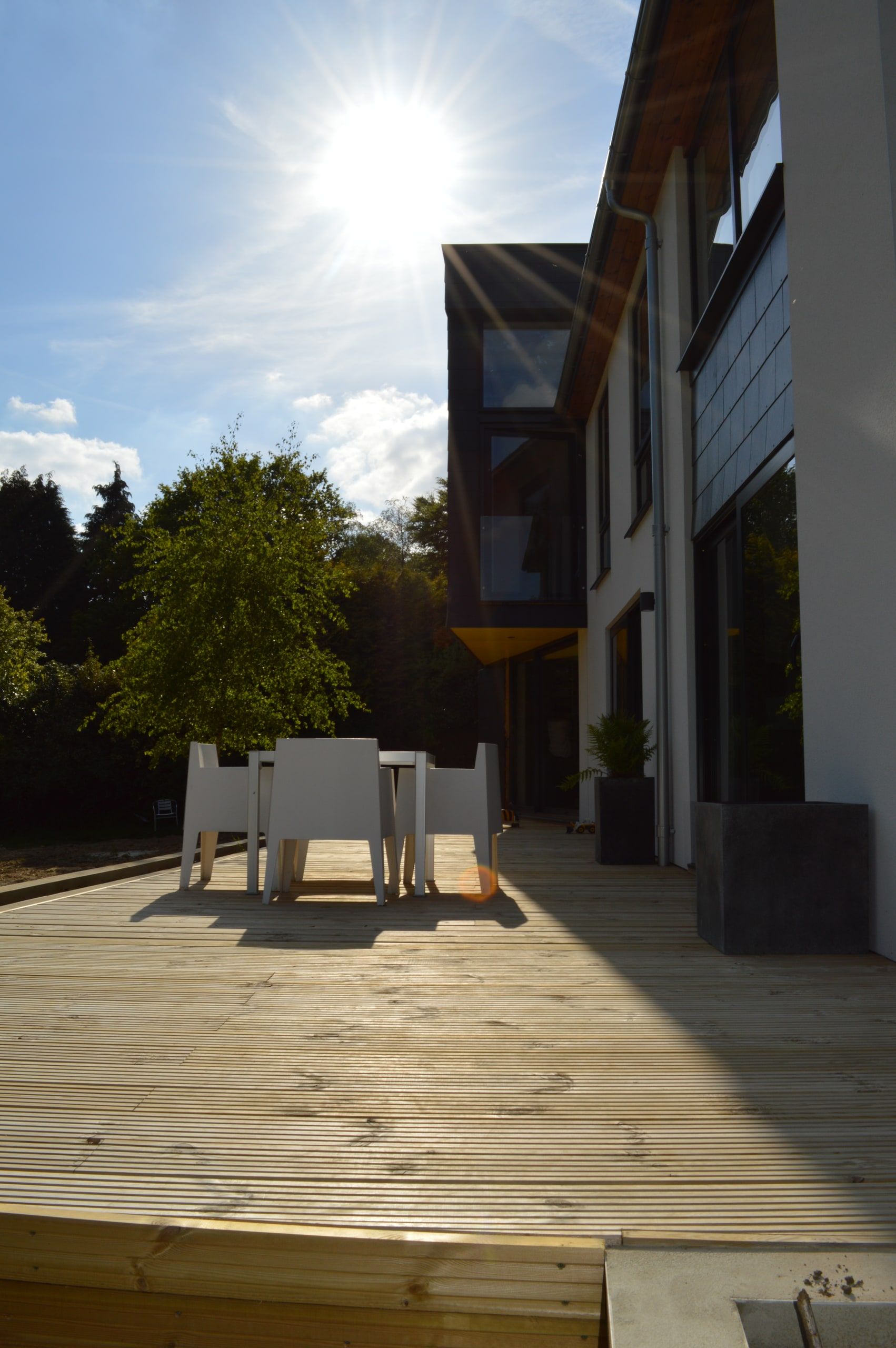 Low sun over the timber terrace, with the cantilevered upper storey above, 1960s house, Haslemere.