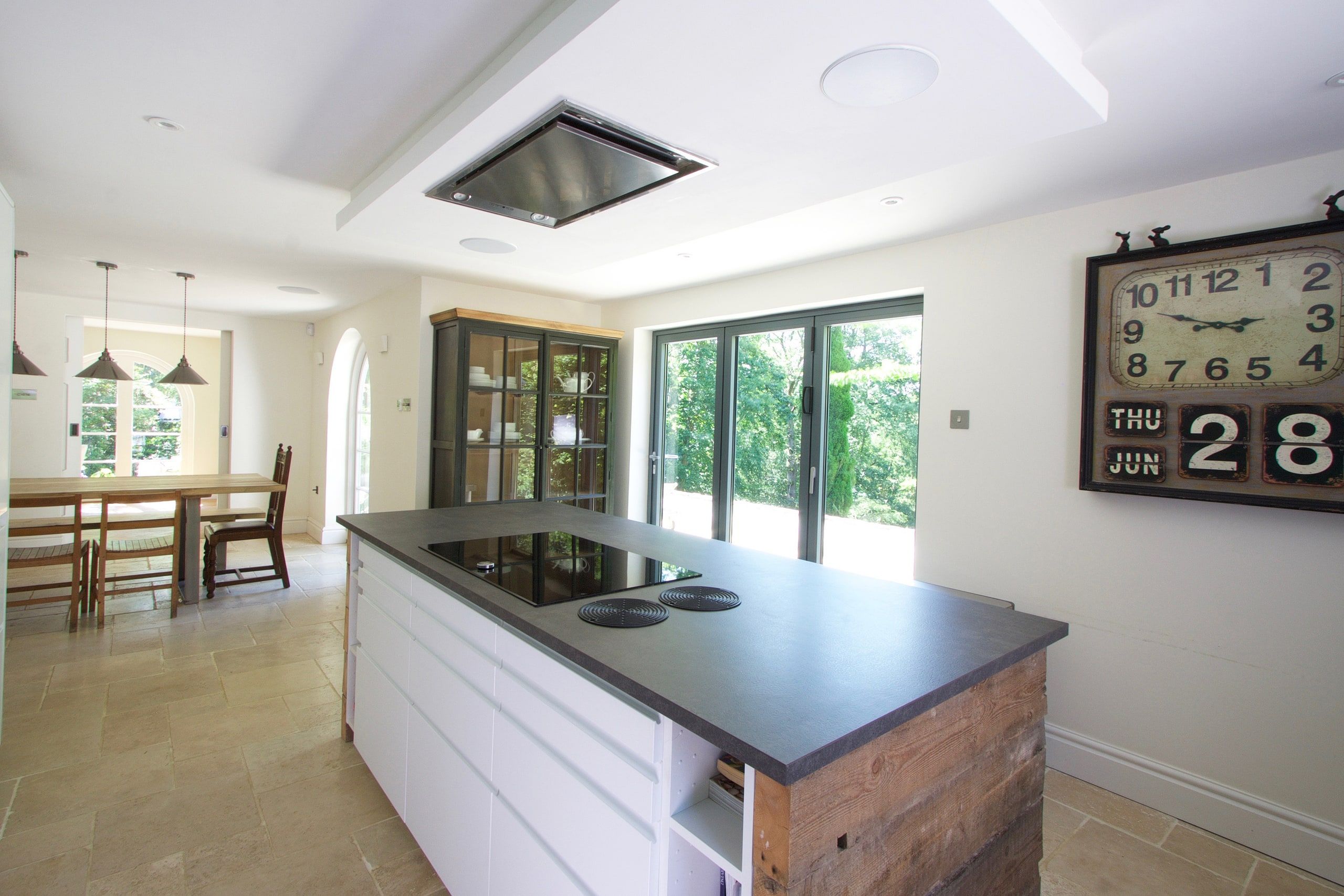 Kitchen island looking through to the dining area and garden doors, 1930s country house, Mole Valley.