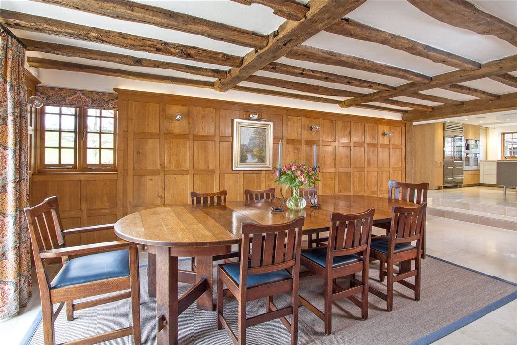 Oak-panelled dining room under exposed beams, Grade II listed country house, Chiddingfold.
