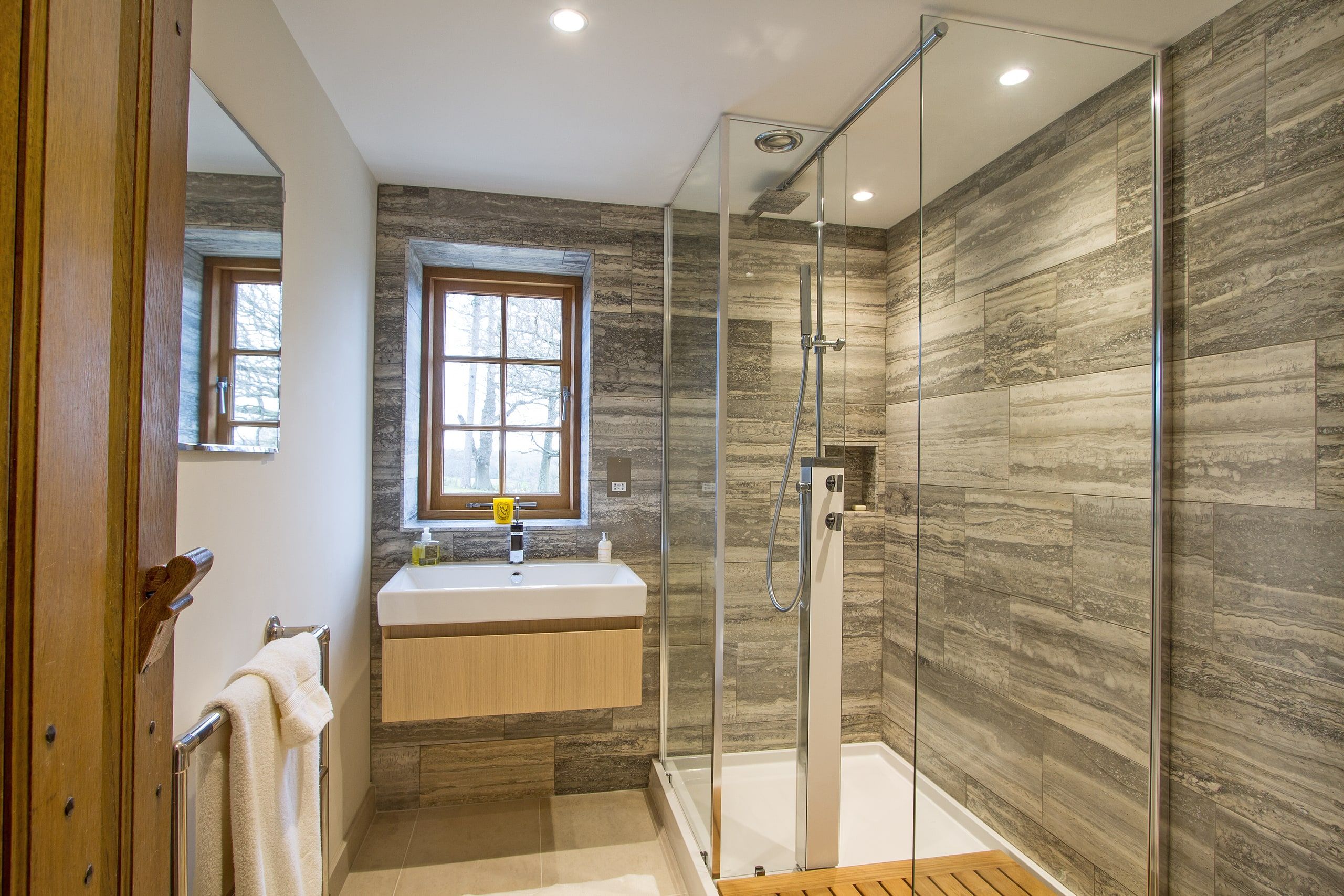 Guest shower room with a glazed walk-in shower and a wall-hung basin, listed country house, Chiddingfold.