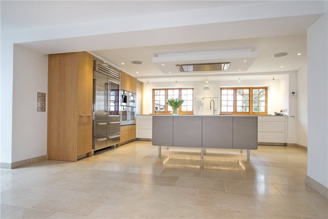 Kitchen island with sink looking towards the windows over the grounds, listed country house, Chiddingfold.