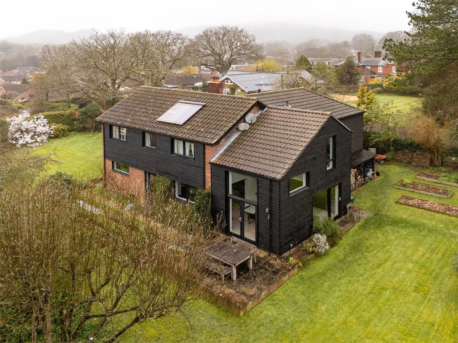 Aerial view of the house and its solar panel in the South Downs National Park, 1960s house, Fernhurst.
