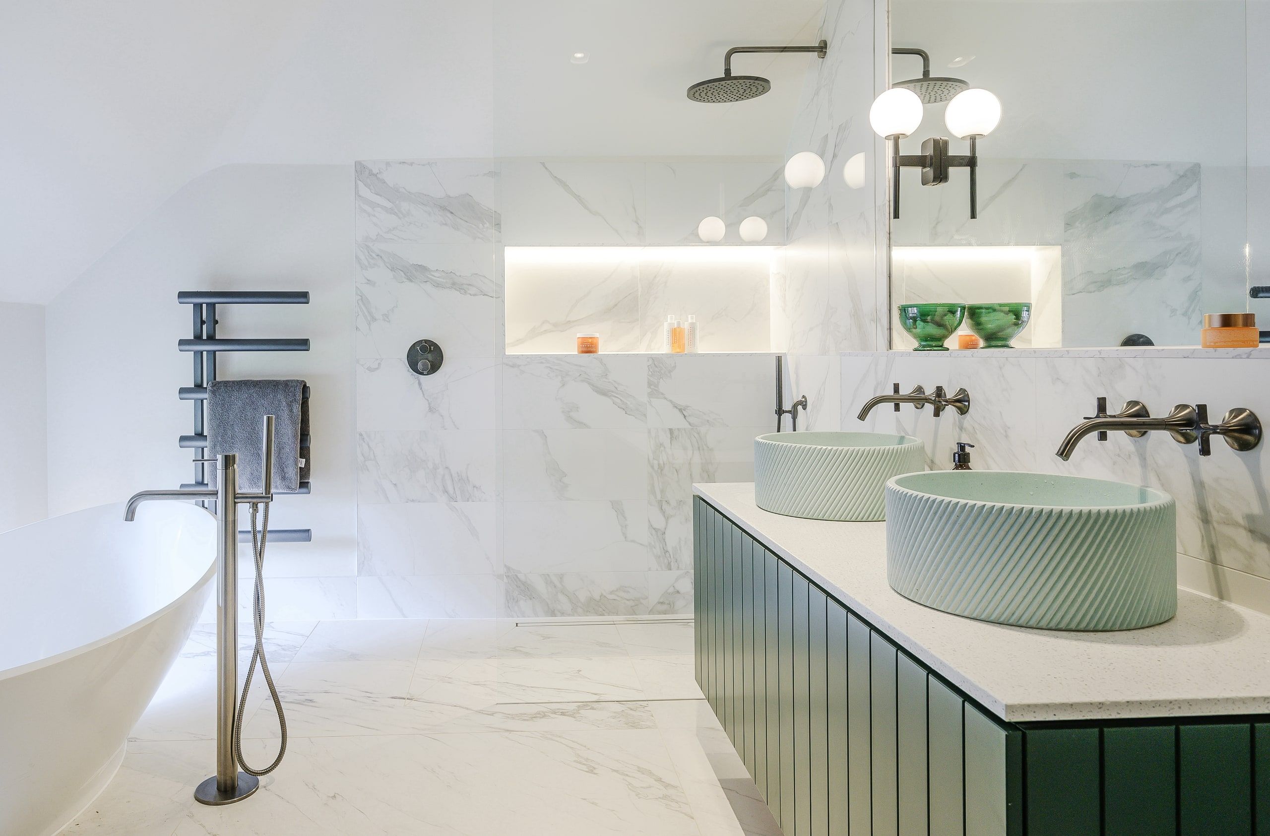 Marble bathroom with a freestanding bath, walk-in shower and twin green basins, country house, Lodsworth.