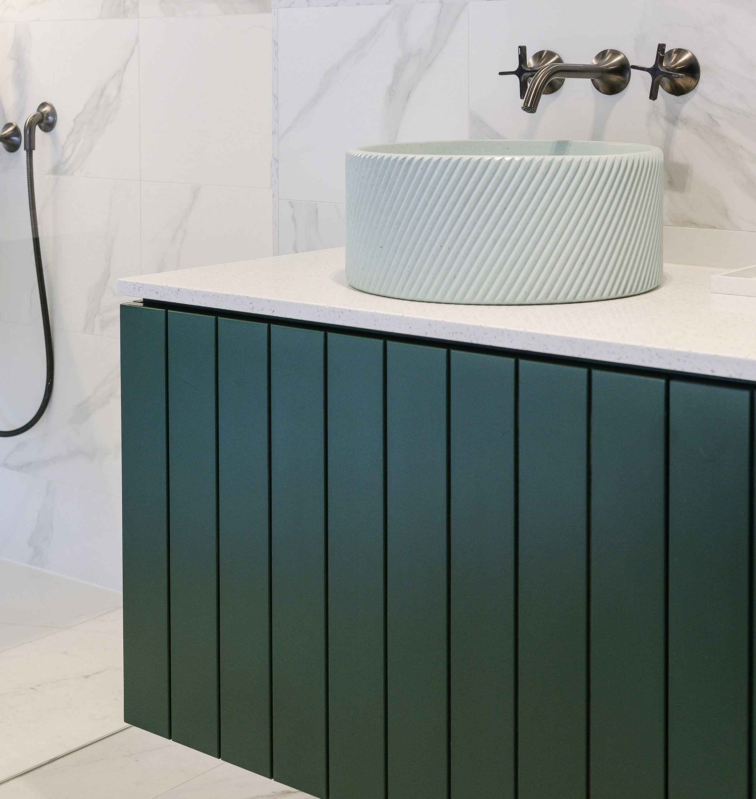 Fluted green vanity unit with a ribbed basin and wall-mounted tap, country house, Lodsworth.