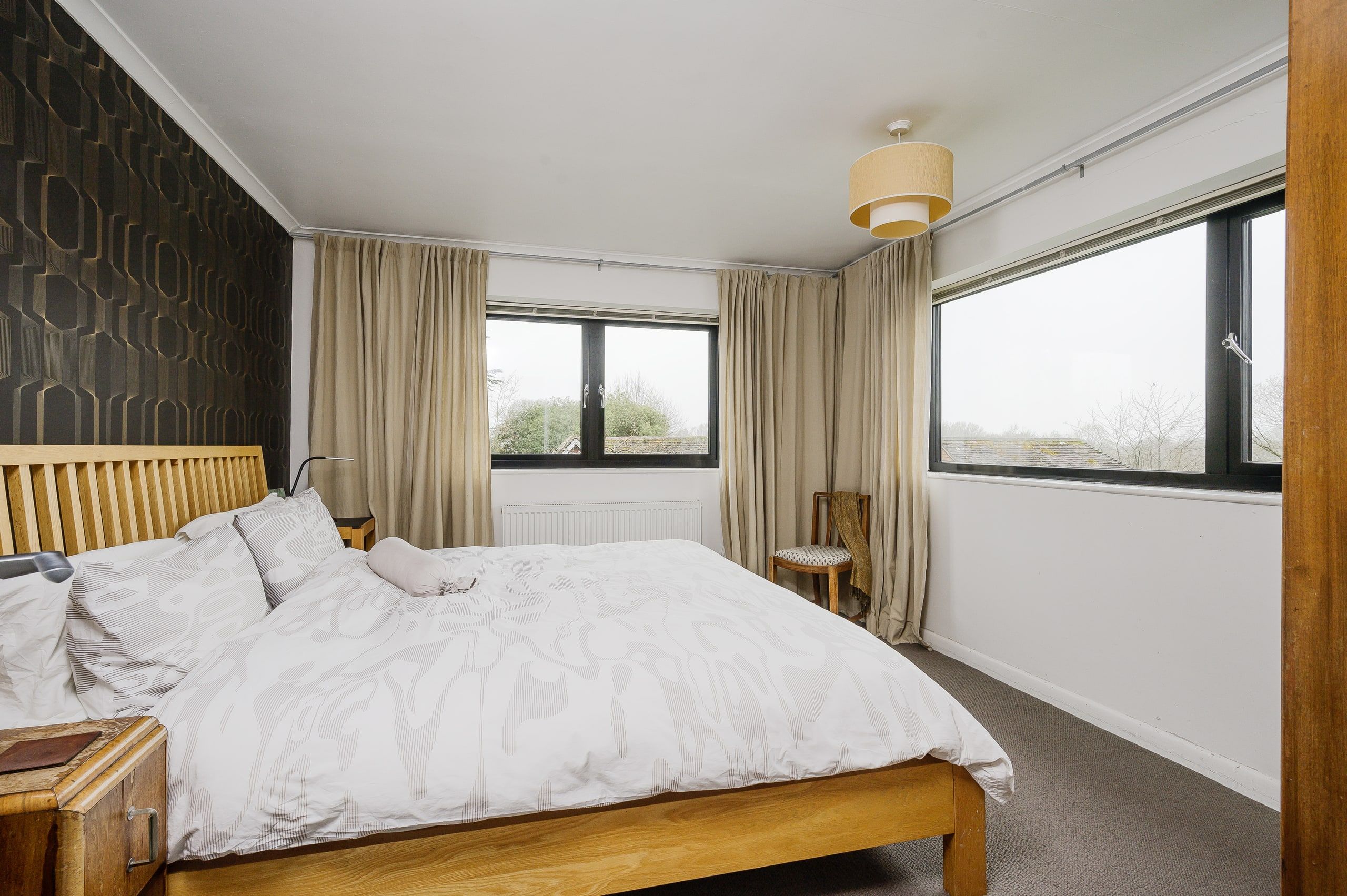 Bedroom with a wide window looking out over the treetops, 1960s house, Fernhurst.