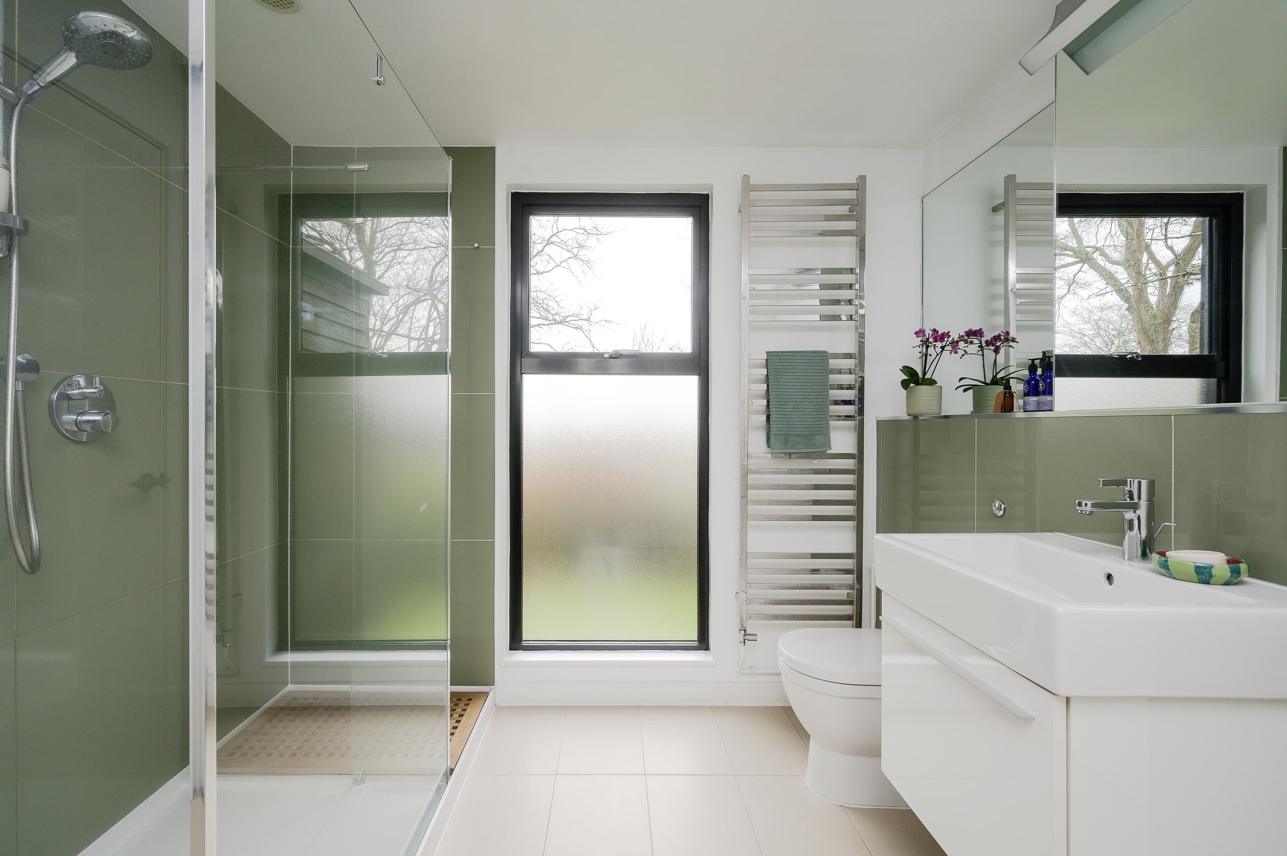 Family bathroom with a wall-hung basin, heated rail and obscured window, 1960s house, Fernhurst.
