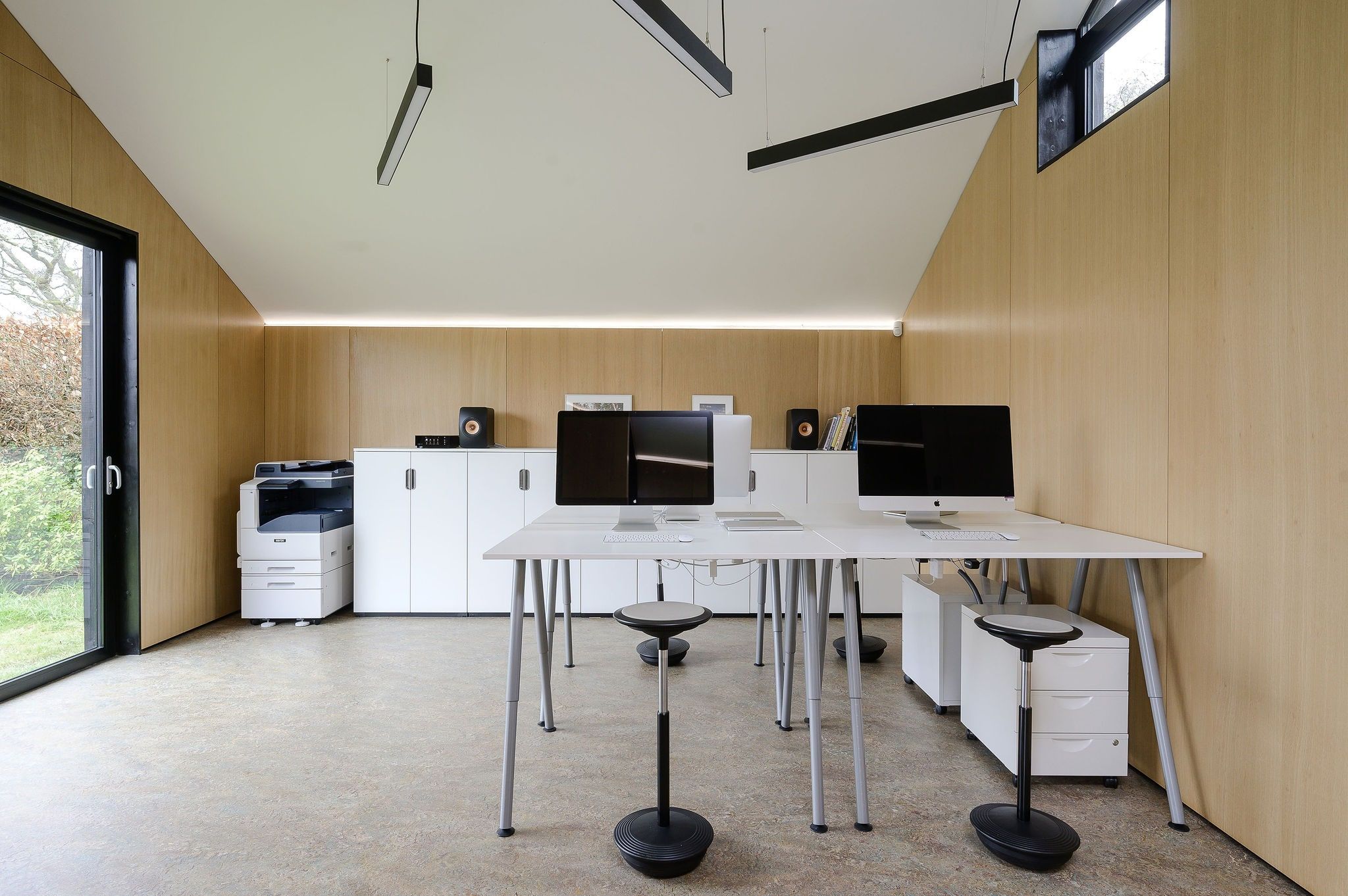 Studio desks and screens under the pitched ceiling, with a glazed door to the garden, ArchitectureLIVE, Fernhurst